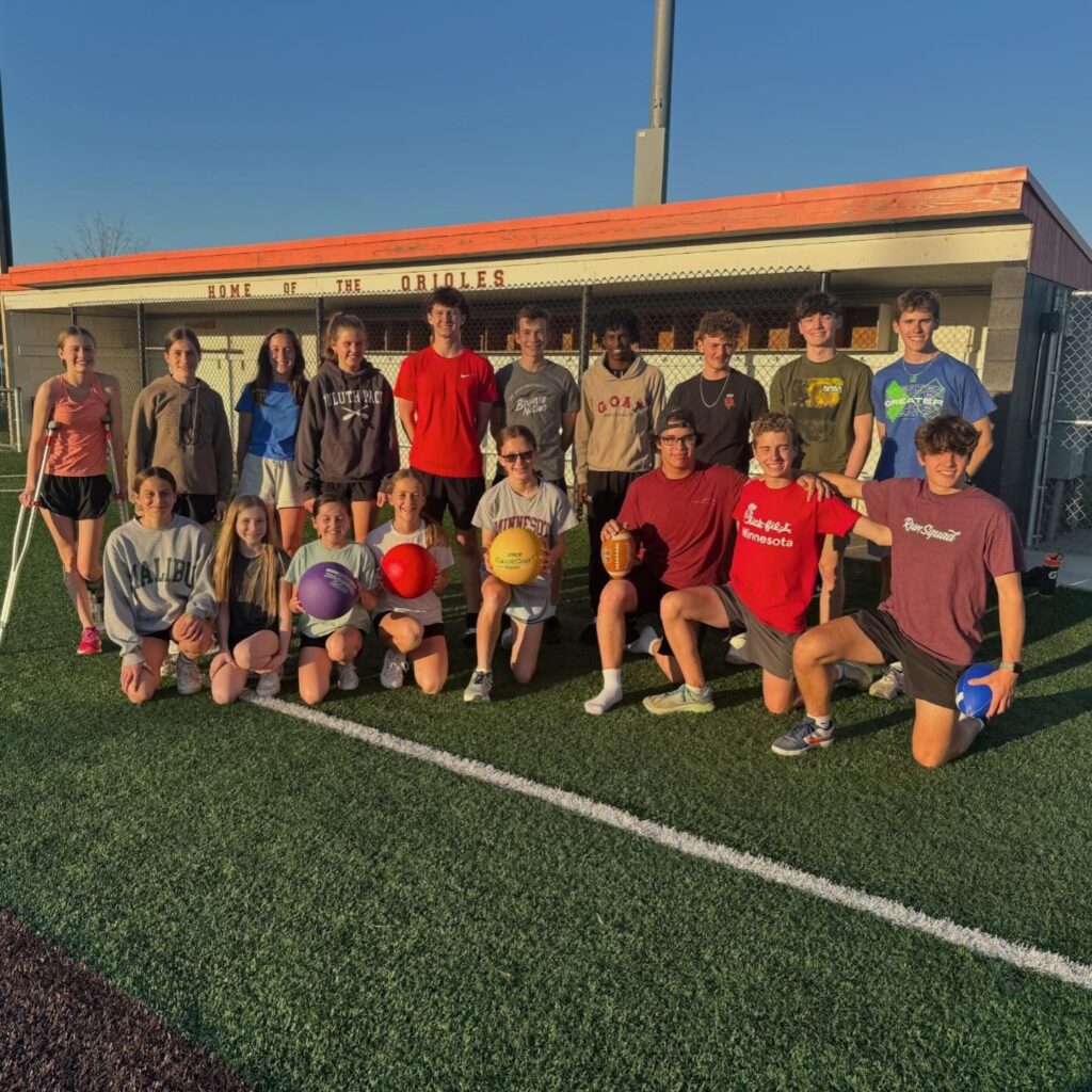 Osseo FCA students with dodgeballs on the turf field at a Fellowship of Christian Athletes dodgeball night