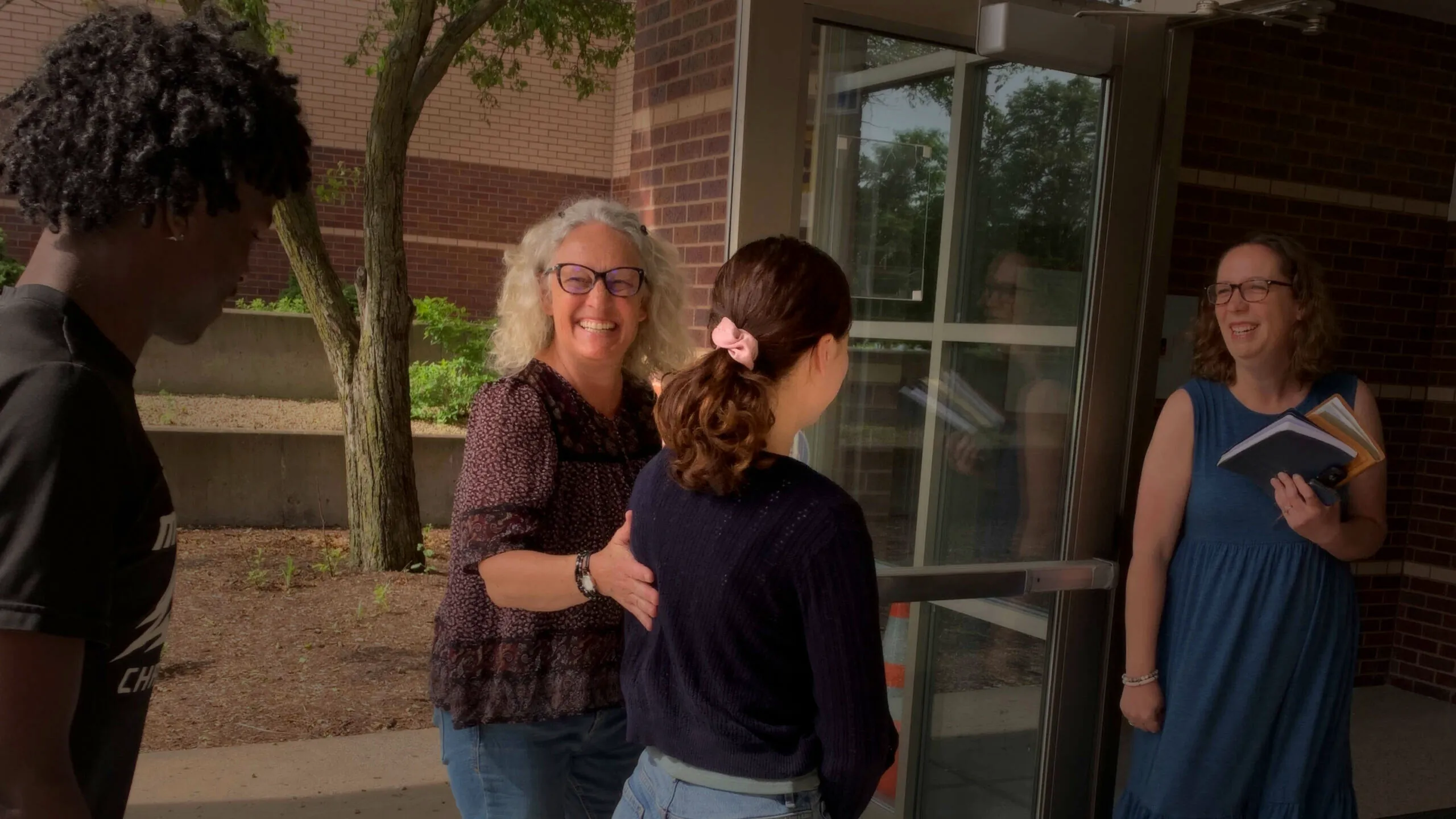 Smiling greeters welcoming people at the school doors before Sunday worship at Clarity Church in Brooklyn Park