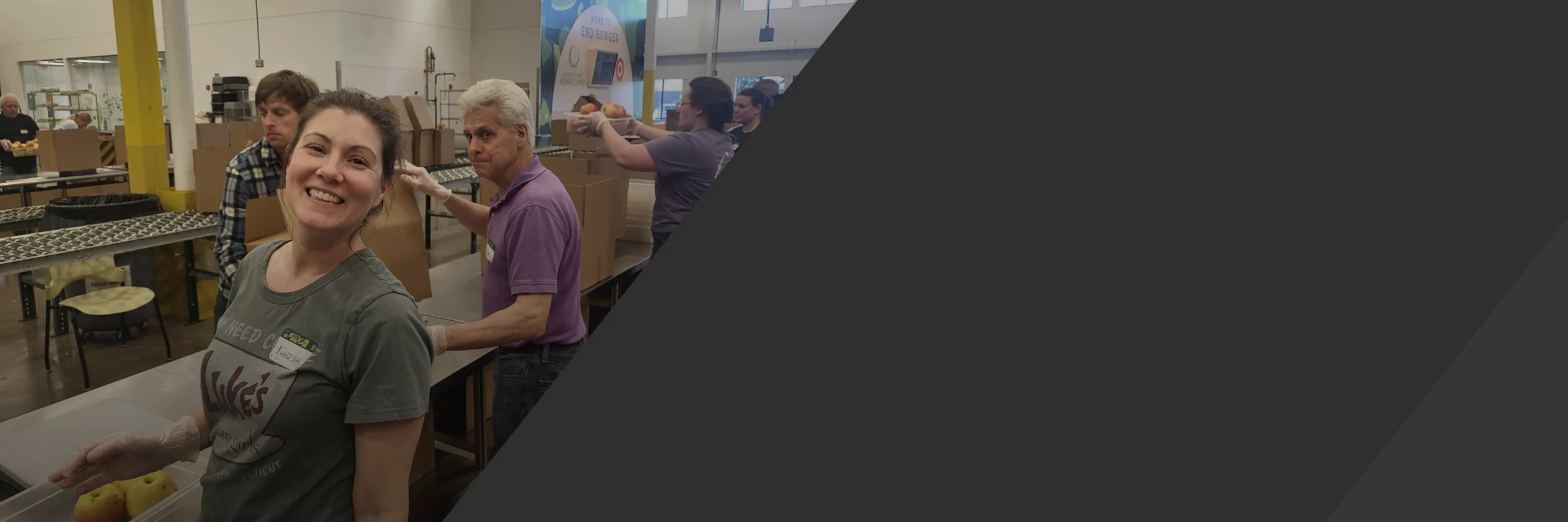 A Clarity Church volunteer smiling while packing food, one way giving serves our Brooklyn Park community