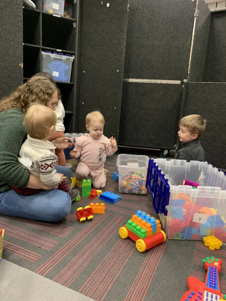A volunteer playing with toddlers in the Clarity Kids nursery on a Sunday morning