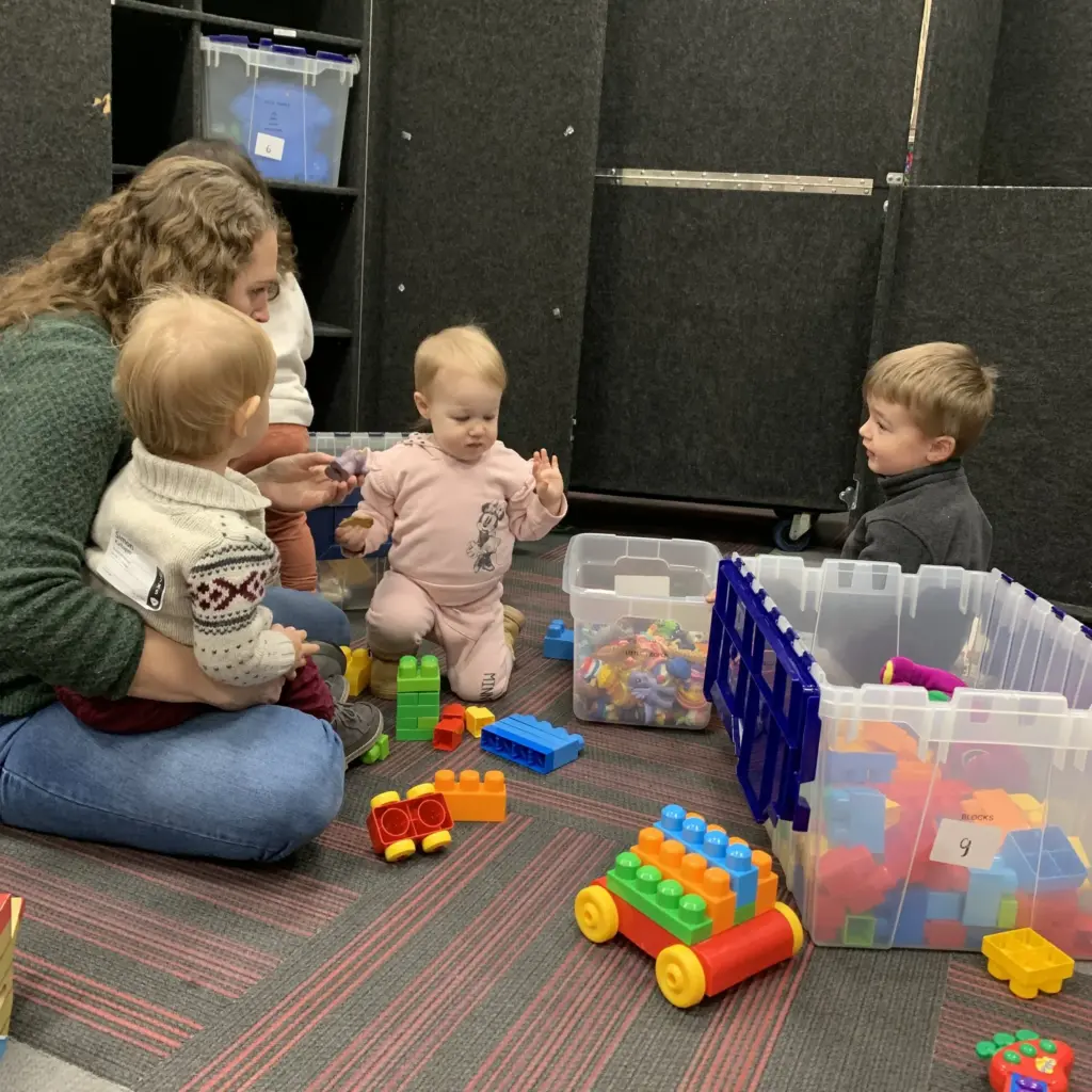 A Clarity Kids volunteer playing with toddlers and building blocks during Sunday worship