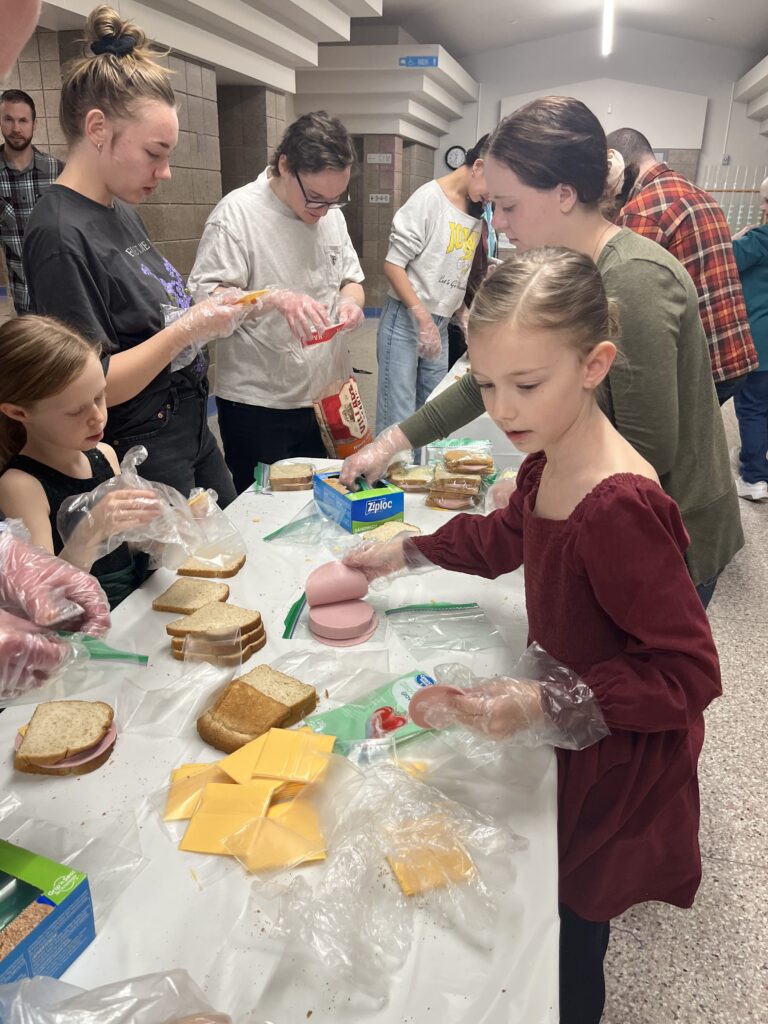 Families making sandwiches together for The Sandwich Project