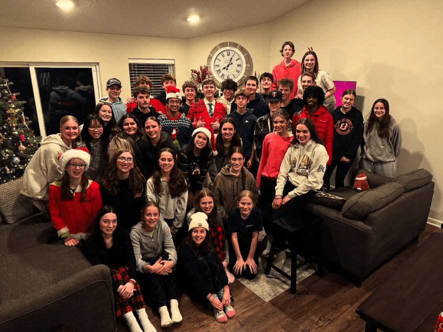 A big group of students in Santa hats at a student ministry Christmas party